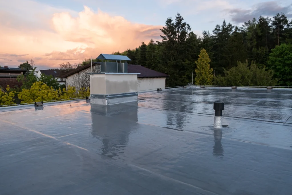 Flat roof covered with bitumen membrane and chimney on home