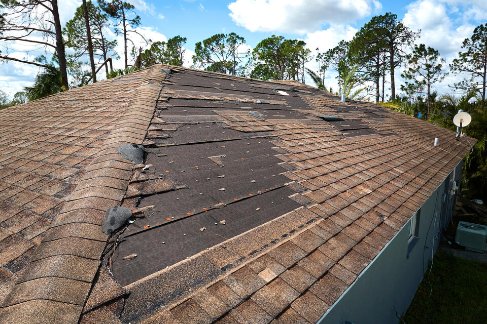 how to get insurance to pay for roof replacement-close up image of damaged roof with missing shingles