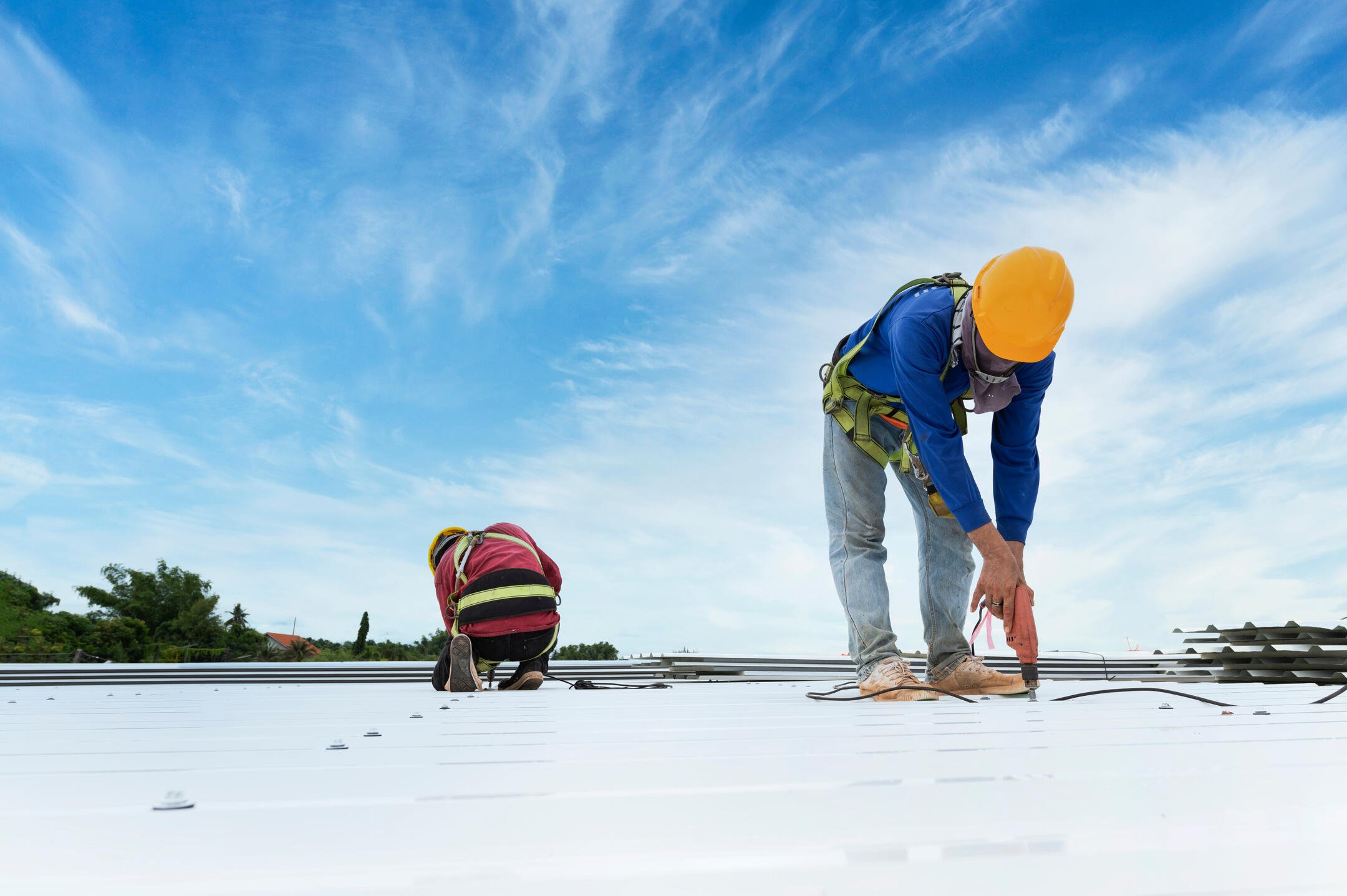 commercial roof leak repair-roofing crew repairing white flat commercial roof