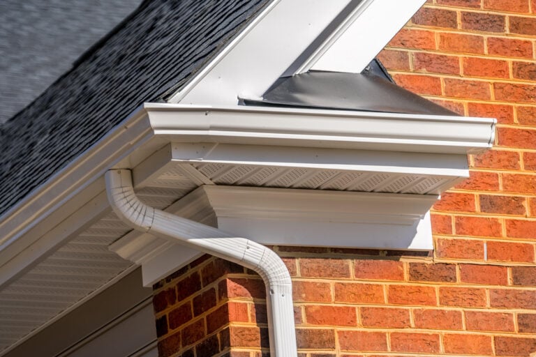 soffit vents-close up of white soffits on red brick house