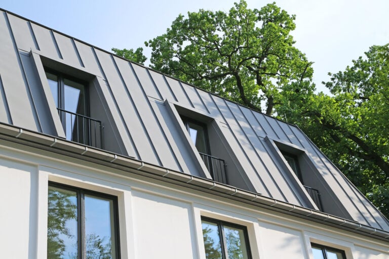 standing seam metal roof-white sided house with gray metal roofing